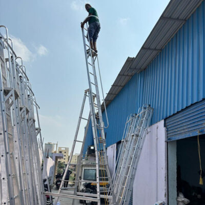 Aluminium self-supporting extension ladder with safety railing and wheels manufactured in Hyderabad for industrial maintenance.